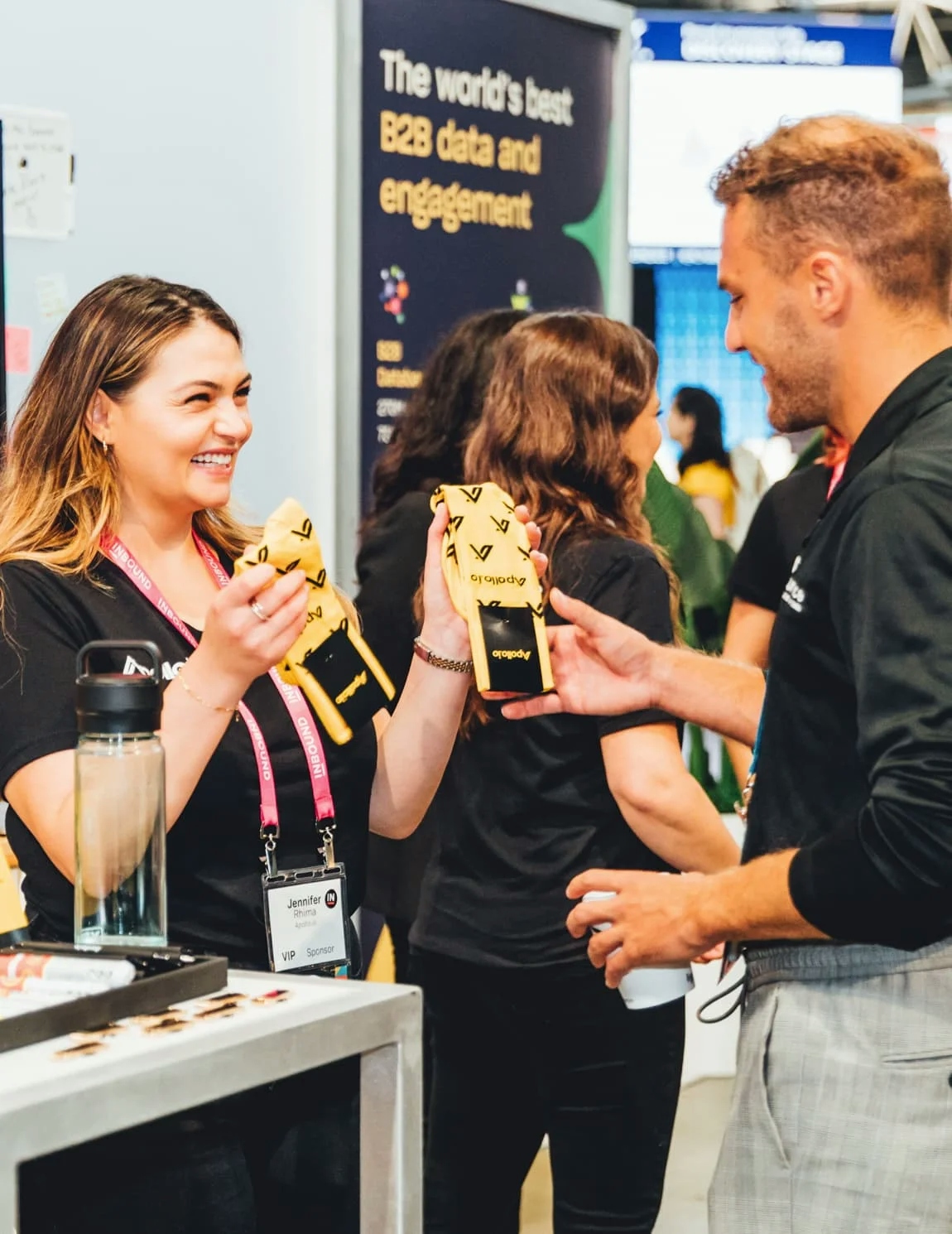 An image of a woman business representative showing off branded merchandise to a male INBOUND attendee